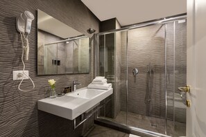 A modern bathroom with a large mirror, a white sink, and a glass shower enclosure. - Spagna Art & Suites - Domus Collection (Rome)