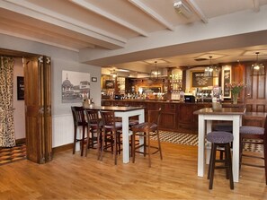 A spacious kitchen with a central island, bar area, and a dining set. - Ye Olde Griffin (March)
