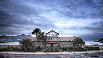A large, two-story building with a symmetrical facade, a central entrance, and a flat roof.