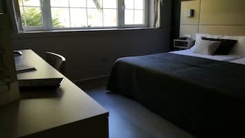 Un dormitorio con cama, mesita de noche y escritorio con silla.