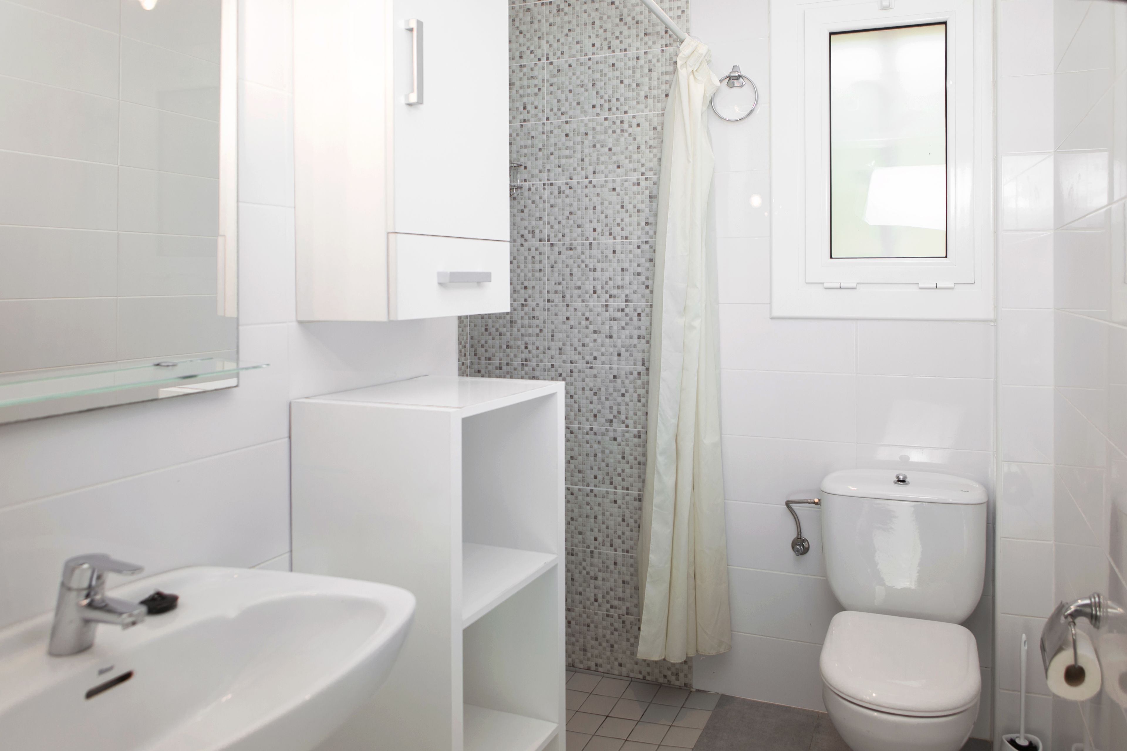 Une salle de bain moderne avec un lavabo blanc, des toilettes et un rideau de douche.