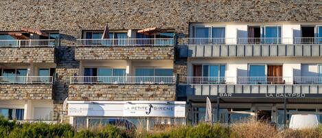 A multi-story hotel with stone facade, balconies, and signage for 'Hôtel - Residence' and 'La Petite Sirène'.