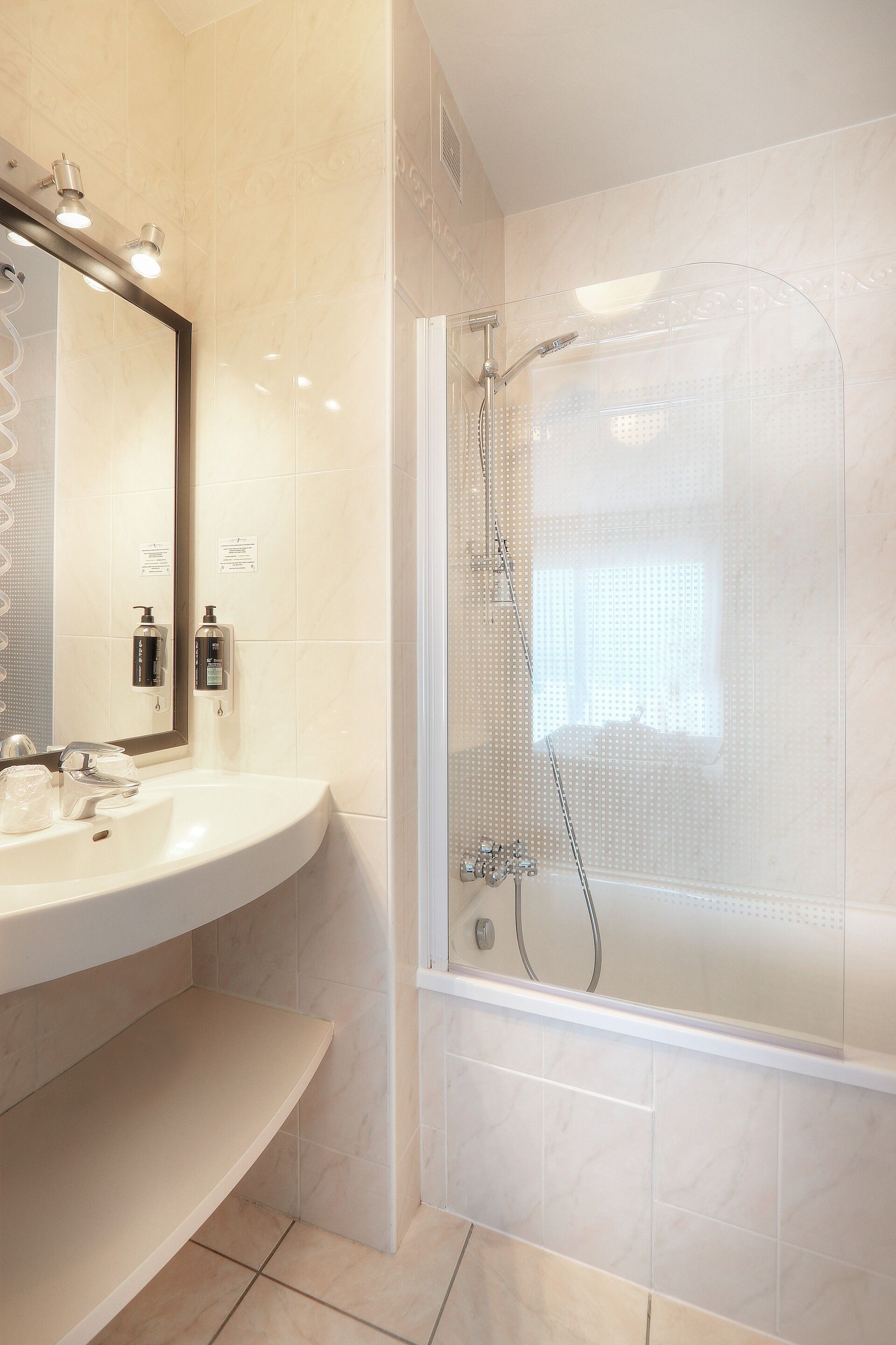 Un baño con lavamanos, espejo y ducha.