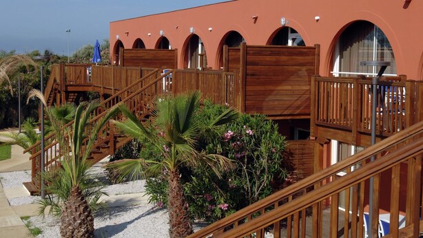 A multi-level wooden structure with outdoor access, surrounded by palm trees and shrubs. - Cap d’Agde Retreat w/ Terrace (LE CAP D'AGDE)