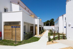 A modern building with a covered outdoor seating area and a clear sky. - Charming Stay by the Sea (Noirmoutier en l'Ile)