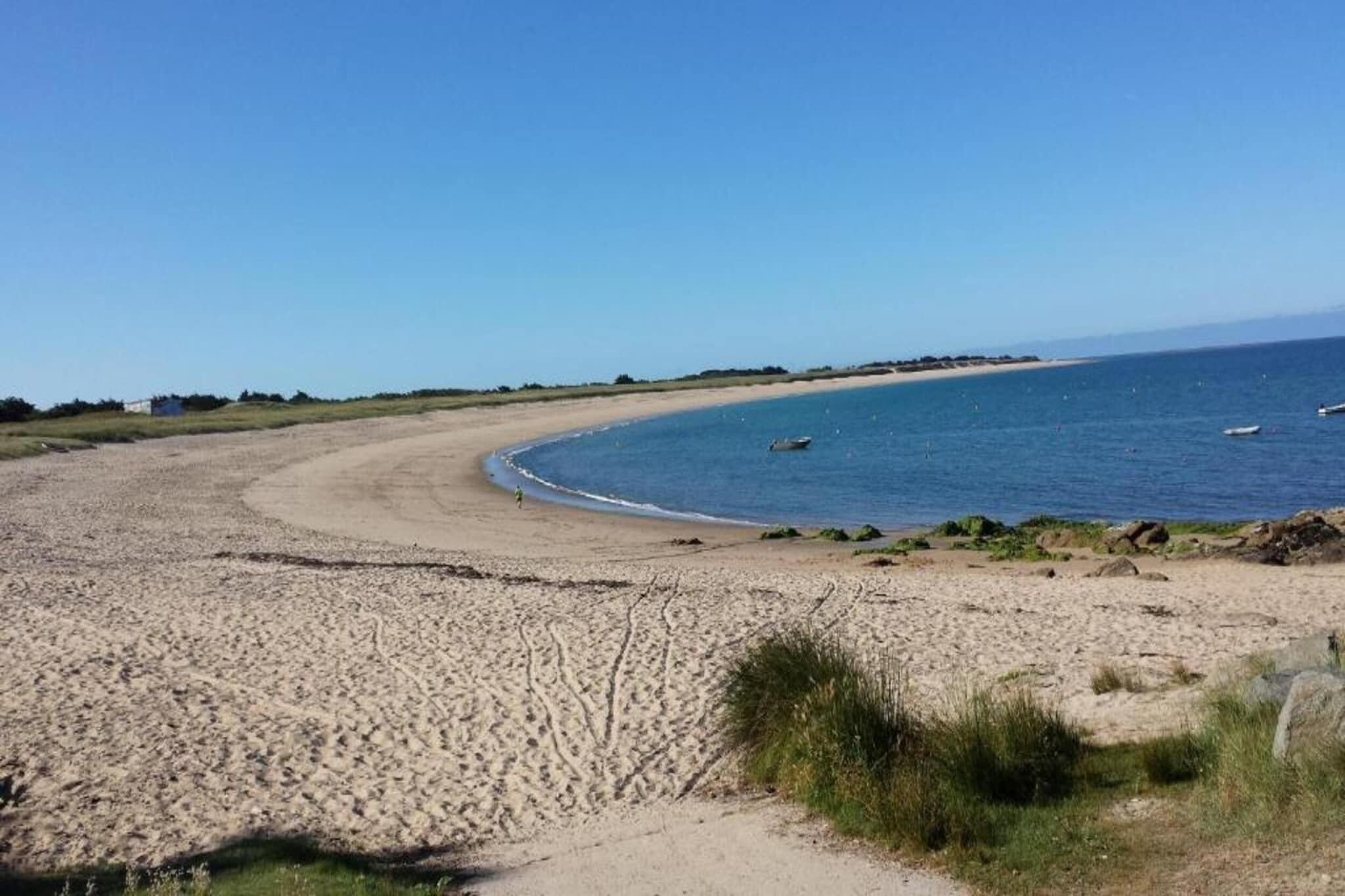Ein sandiger Strand mit klarem Himmel und ruhiger See.