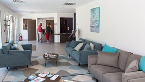 Un salon moderne avec des canapés, une table basse et un comptoir d’accueil.