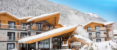 A modern ski resort with wooden cabins and a mountain backdrop.