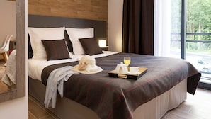 Een moderne hotelkamer met een groot bed, een nachtkastje en uitzicht op de omgeving.