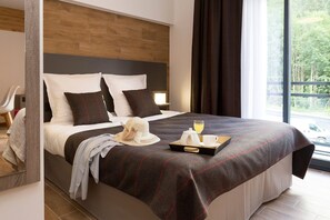 Ein modernes Hotelzimmer mit einem großen Bett, einem Nachttisch und Blick ins Freie.