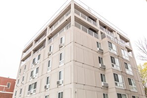 A multi-story building with balconies, windows, and air conditioning units. - Harvard Square Apartments by Next Star (Cambridge)