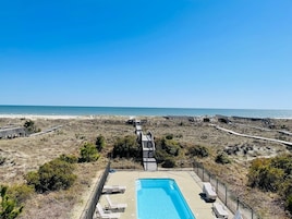 Zona de piscina con vista despejada a la playa y al océano.