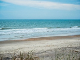 Una playa con orilla arenosa y olas suaves.