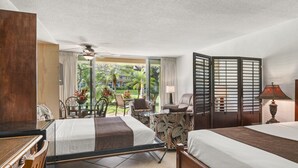 A hotel room with a bed, a desk, a chair, a table, and a view of the outdoors. - Maui Kaanapali S #b133 Studio Bedroom Condo by RedAwning (Lahaina)