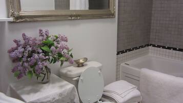 A bathroom with a toilet, sink, mirror, and bathtub.
