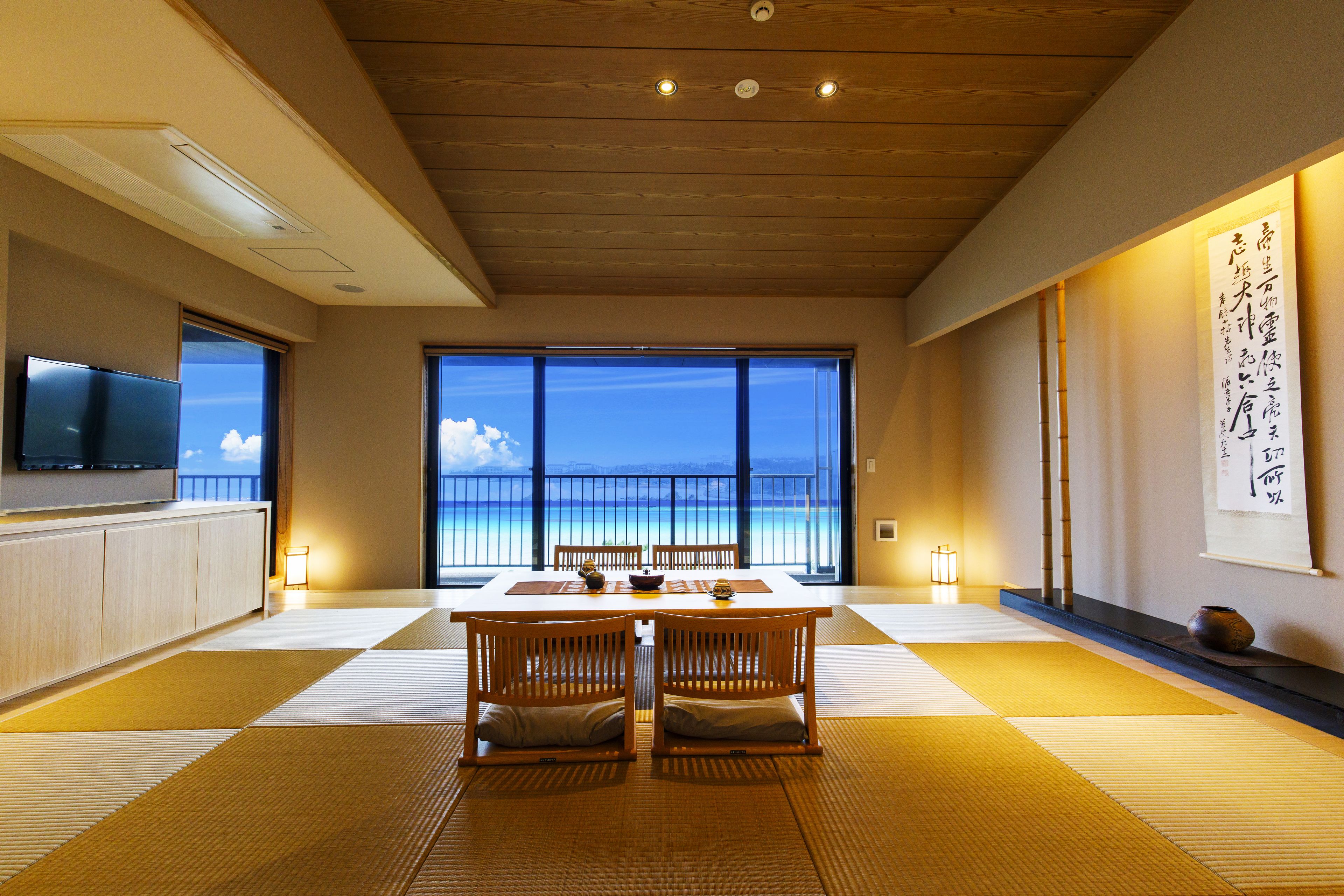 A traditional Japanese room with tatami flooring, a low table, and a television on the left.