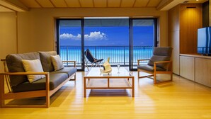 A modern living room with a sofa, two armchairs, a coffee table, and a TV. The room has large windows offering a view of the ocean. - Umino Ryotei Okinawa Nakamasou (Onna)