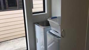 Un área de lavandería con lavadora, secadora y lavabo.