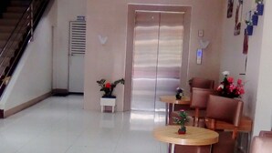 A spacious lobby with a staircase, a reception desk, and seating areas. - Meaco Hotel - Solano (Solano)