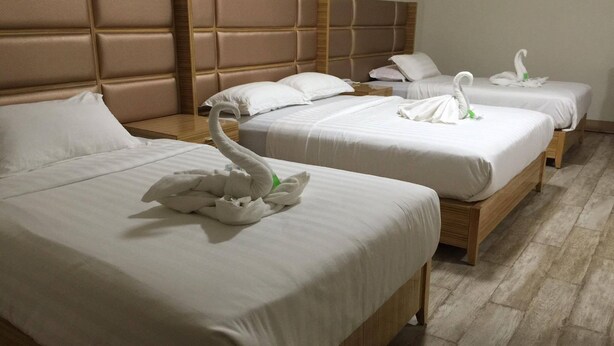 A hotel room with three beds, each with white bedding and a swan-shaped decoration. - Meaco Hotel - Solano (Solano)