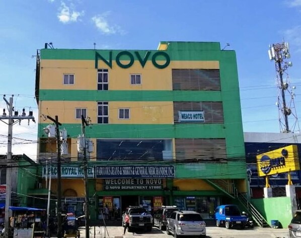 A multi-story building with a green and yellow facade, a sign for 'NOVO Department Store', and a 'WEACO HOTEL' sign on the upper floor. - Meaco Hotel - Solano (Solano)
