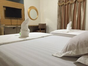 A hotel room with two beds, a flat-screen TV mounted on a wooden panel, a round mirror, and a window with curtains. - Meaco Hotel - Solano (Solano)