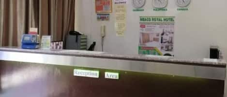 A reception desk at Meaco Royal Hotel Solano Branch with a clock, a 'No Pets Allowed' sign, and a 'Reception Area' label.