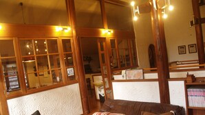 Una sala de estar acogedora con un sofá de cuero marrón, una mesa de centro de madera y una estantería.