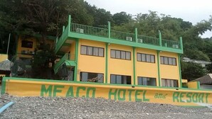 A two-story building with a green and yellow facade, labeled "MEACO HOTEL and RESORT". - Meaco Hotel - Anilao (Mabini)