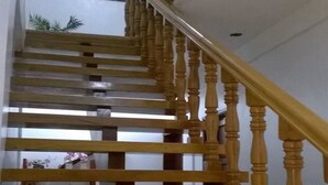 A wooden staircase with a handrail, leading to an upper floor. - Meaco Hotel - Anilao (Mabini)