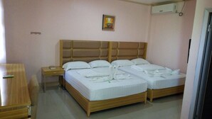 A hotel room with two beds, a wooden headboard, a nightstand, and a desk. - Meaco Hotel Legazpi (Legazpi)
