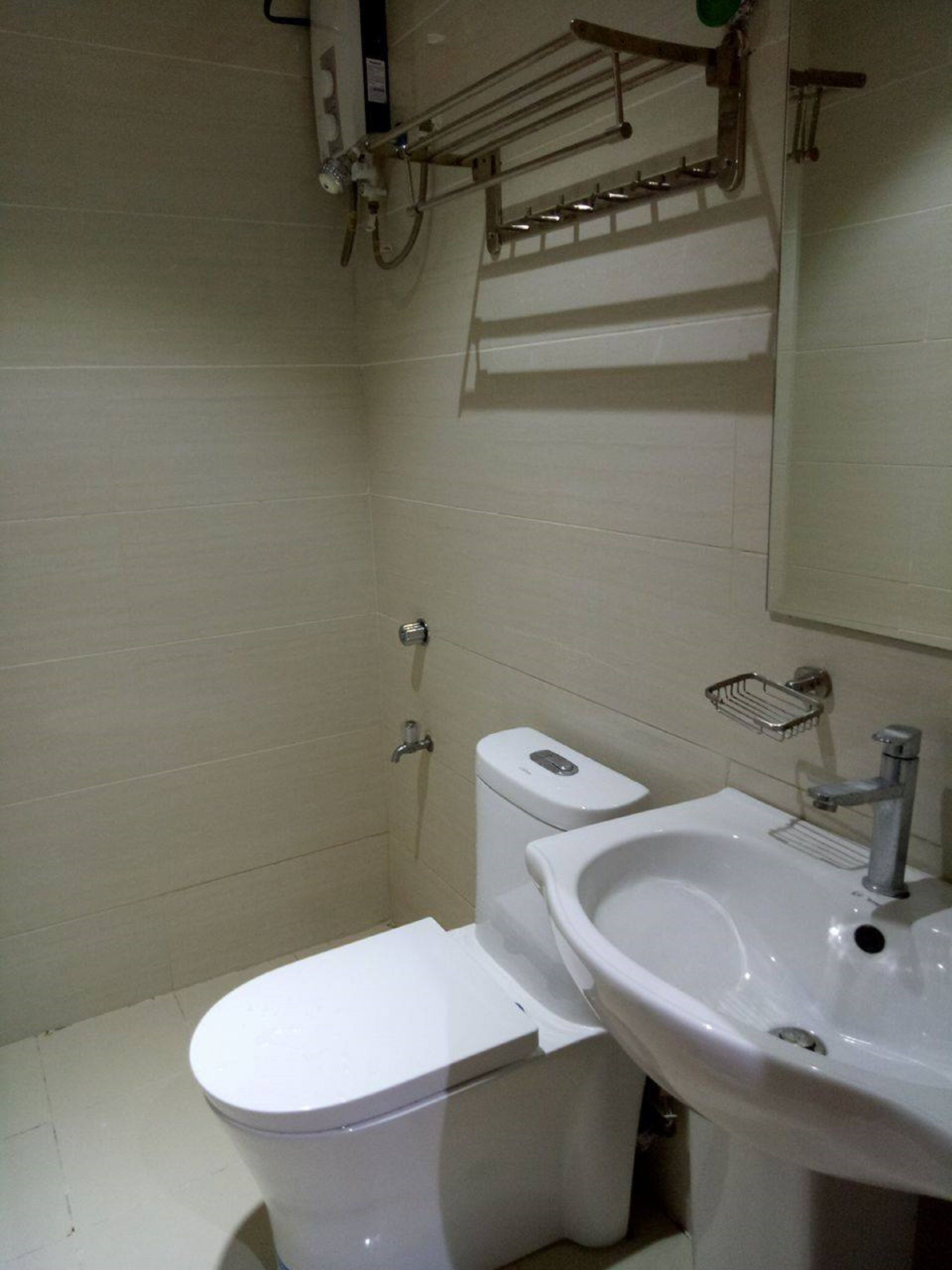 Un baño con inodoro, lavabo y espejo.