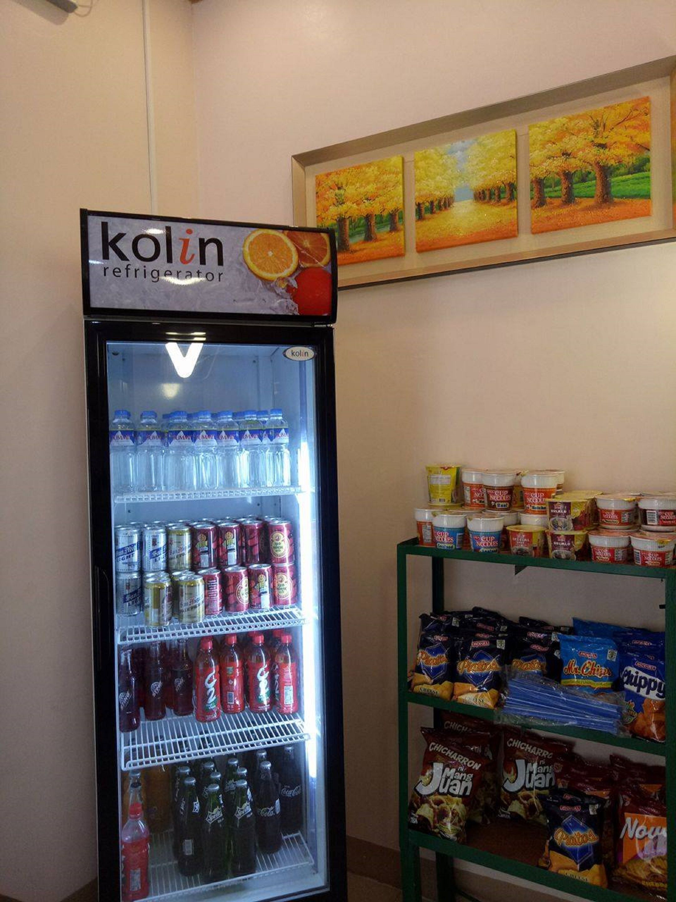 A refrigerator with a 'kolin' sign, stocked with beverages and snacks.