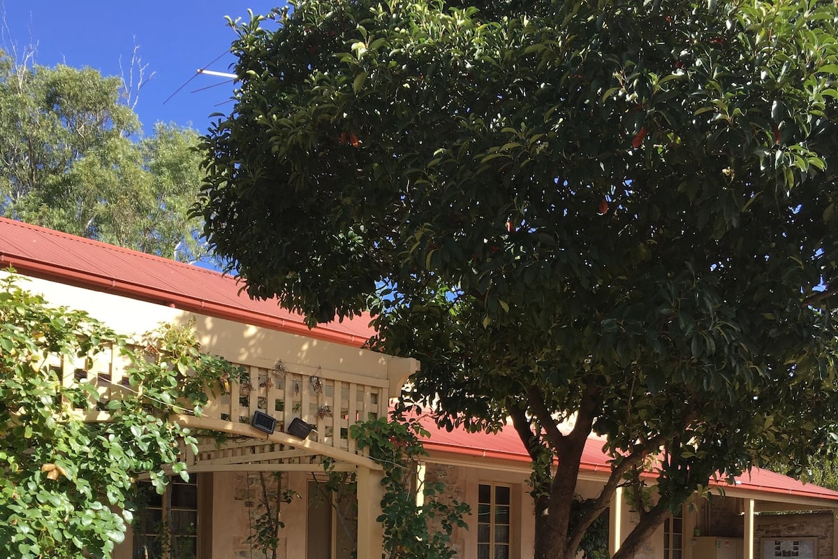 Un edificio con techo rojo, paredes de piedra y un patio de ladrillo.