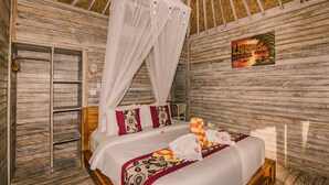 A room with a bed, a canopy, a painting, and wooden walls. - The Bridge Huts (Ceningan Island)