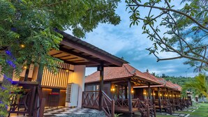 A resort with outdoor seating areas, stone steps, and a checkered floor pattern. - The Bridge Huts (Ceningan Island)