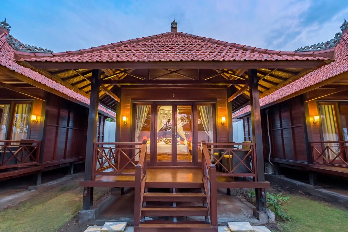A traditional wooden building with a tiled roof and a central entrance with steps.