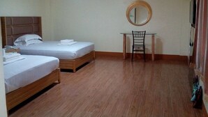 A hotel room with two beds, a desk with a chair, a round mirror, and a ceiling light. - Meaco Hotel - Dipolog (Dipolog)