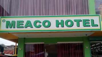 Un letrero de hotel con el nombre 'MEACO HOTEL' en letras negritas.