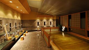 A traditional Japanese onsen with multiple bathing areas, wooden floors, and tiled walls.