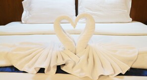 A bed with white linens and a heart-shaped towel arrangement. - Life Up Resort and Spa (San Sai)