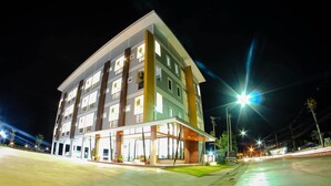 A multi-story hotel with a flat facade, large windows, and a well-lit entrance area.