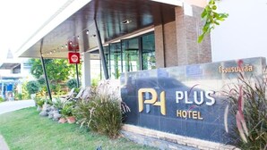 A hotel entrance with a sign reading "PLUS HOTEL" and a sign indicating a NIDA location.