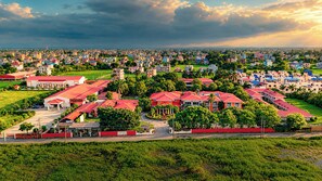 Un barrio residencial con varias casas, un edificio central con techo rojo y zonas verdes circundantes.