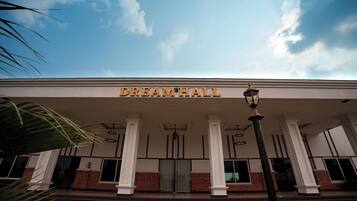 A building with a sign reading 'DREAMHALL' above the entrance, featuring a classical architectural style with columns and a brick facade.