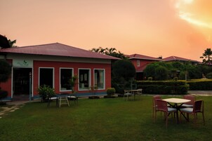 Un edificio rojo con un letrero que dice 'Terra Fresh Restaurant' y un césped bien cuidado con mesas al aire libre.