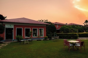 Un edificio rojo con un letrero que dice 'Terra Fresh Restaurant' y un césped bien cuidado con mesas al aire libre.