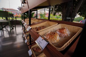 Se muestran cestas de pan con etiquetas, una mesa de madera y vistas al exterior.
