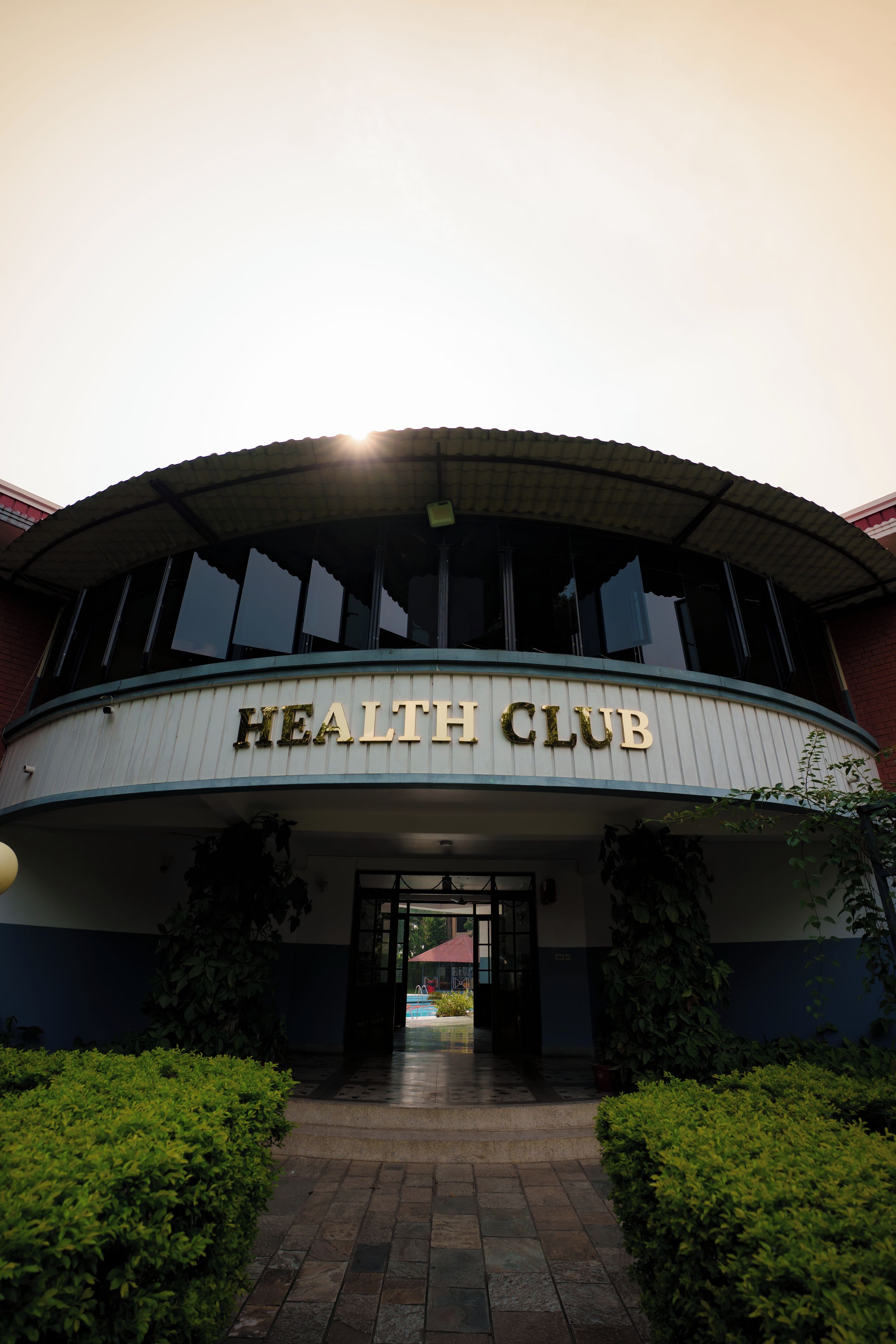 Un bâtiment dont l’entrée est marquée par une enseigne indiquant « CLUB DE SANTÉ ».