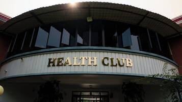 Un bâtiment dont l’entrée est marquée par une enseigne indiquant « CLUB DE SANTÉ ».